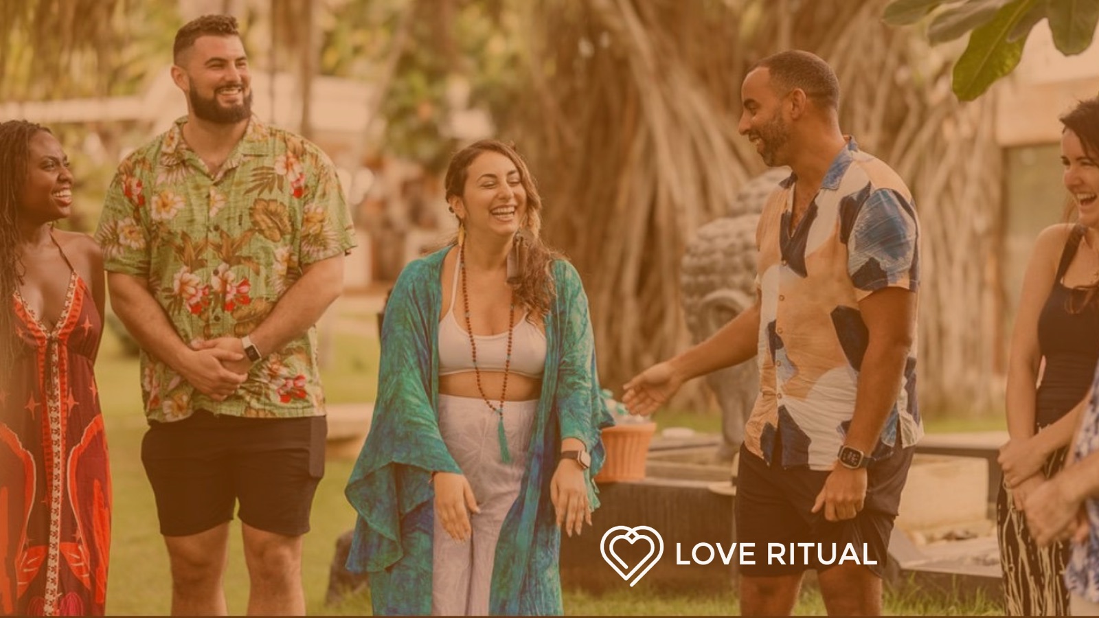 Five people laughing together on the grass at a Love Ritual cacao ceremony and connection circle