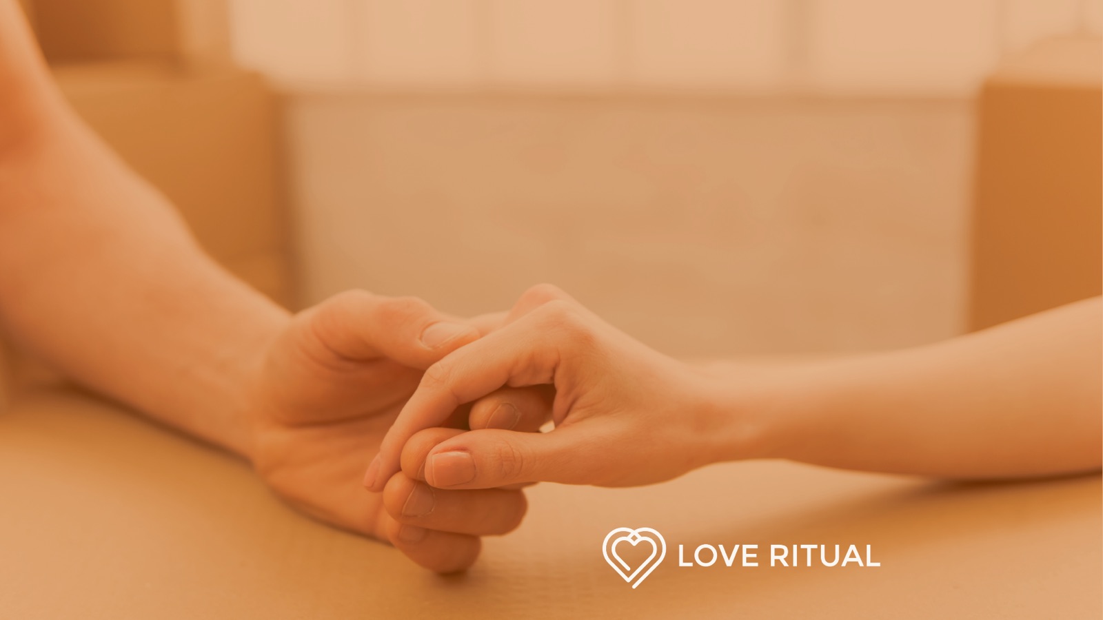 Two people holding hands across a table